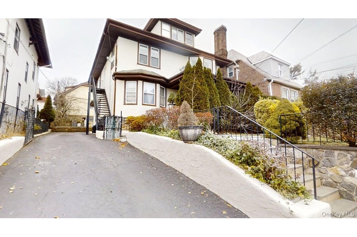 View of front facade with stucco siding and stairway