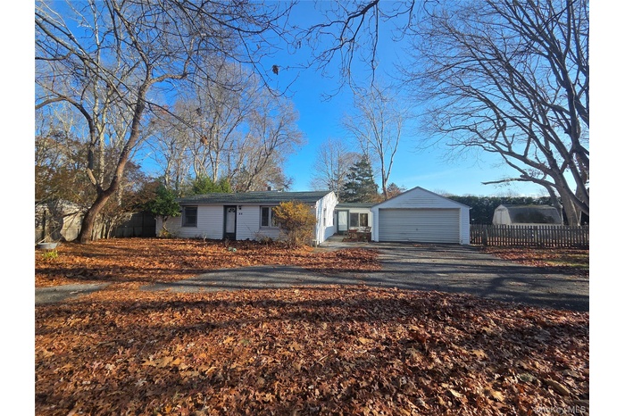 Single story home featuring a garage and driveway