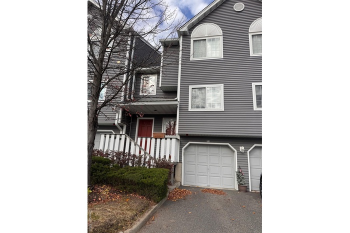 Traditional home with covered porch and asphalt driveway