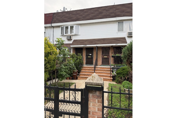 View of front of home featuring a shingled roof, a gate, mansard roof, and a fenced front yard