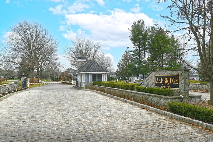 View of road with curbs, a gated entry, and traffic signs