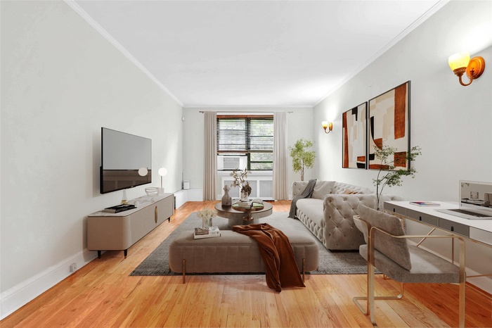 Living room featuring crown molding, light wood-style floors, and cooling unit