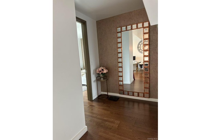 Hallway with dark wood-style floors and a desk
