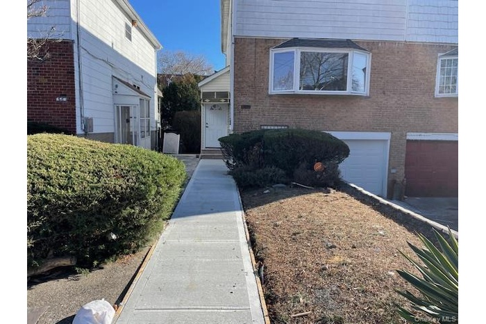 View of exterior entry with brick siding and an attached garage