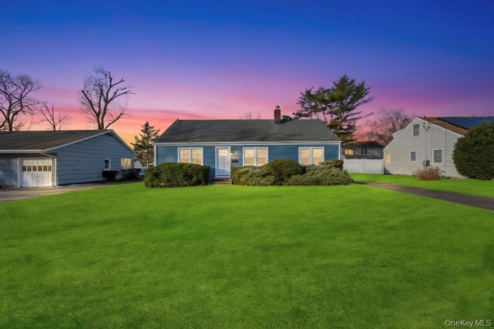 View of front of house with a chimney and a garage