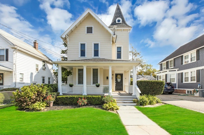 View of front of property with a porch and a front yard