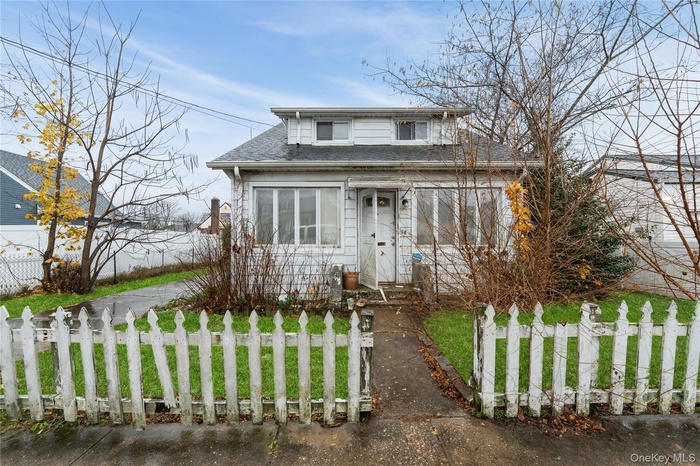 View of front of house featuring a fenced front yard and roof with shingles