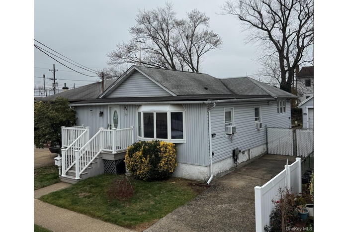 View of front of home with a shingled roof and a deck