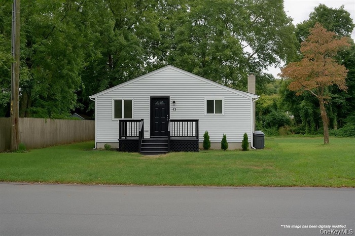 Bungalow featuring view of wooded area, a chimney, and a deck