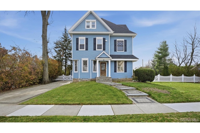 View of front of property featuring a gate and roof with shingles