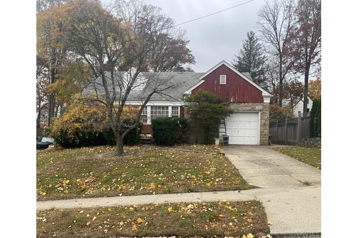 View of front of property featuring concrete driveway and a garage