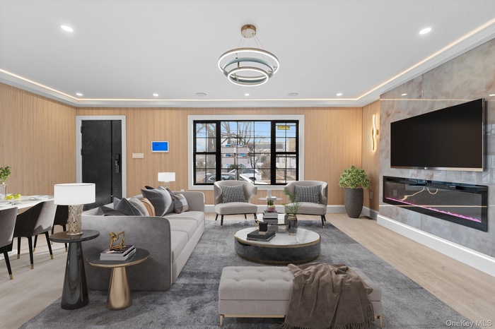Living area featuring a large fireplace, light wood finished floors, and recessed lighting