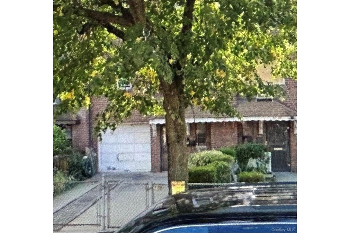 View of front of home featuring brick siding and a swimming pool