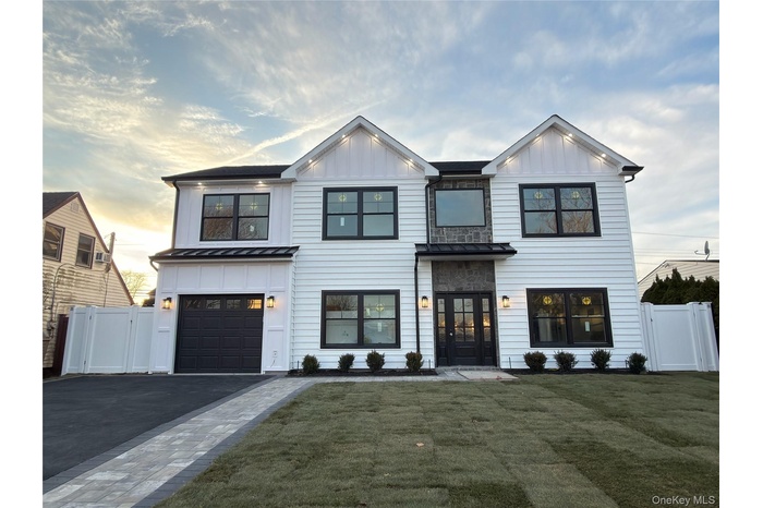 Modern farmhouse style home with board and batten siding, a standing seam roof, driveway, and a metal roof