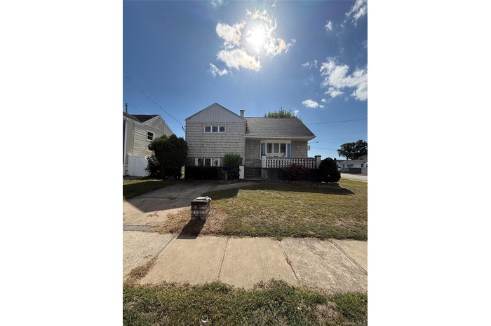 View of front facade featuring a front lawn and covered porch