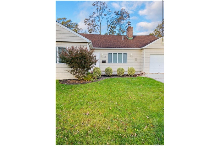 Single story home featuring a front lawn, a shingled roof, a chimney, and a garage
