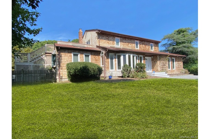 Back of property with stairs and a chimney
