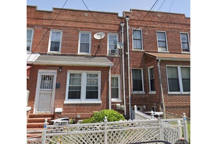 Traditional home featuring a fenced front yard, brick siding, and entry steps