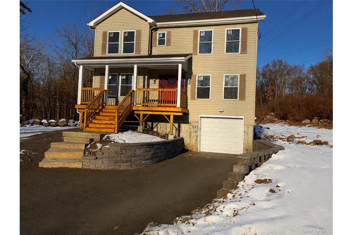 View of front of property with covered porch and an attached garage