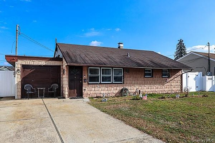 View of front of home featuring an attached garage, driveway, and a gate