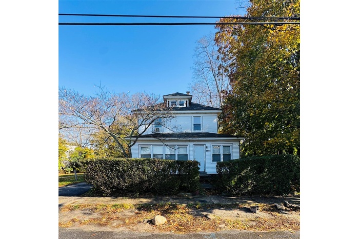 American foursquare style home featuring a chimney