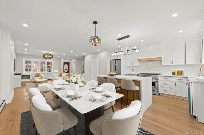 Dining room with recessed lighting, light wood-style floors, a chandelier, and stairway