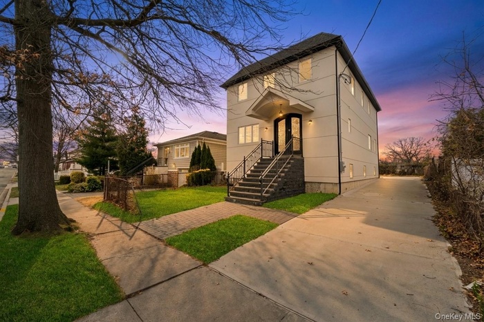View of front of property featuring a yard and concrete driveway