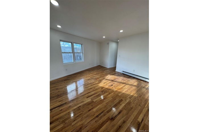 Spare room featuring recessed lighting, baseboard heating, and light wood-style floors