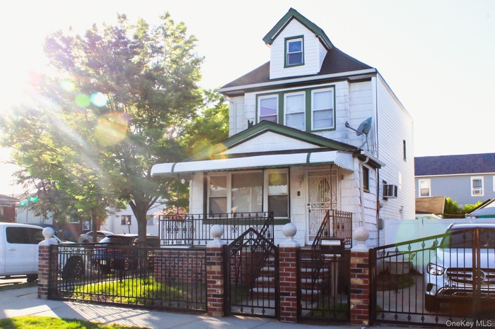 Traditional style home featuring a gate, a porch, and a fenced front yard