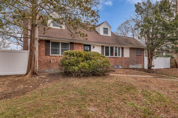 View of front of home with brick siding and roof with shingles