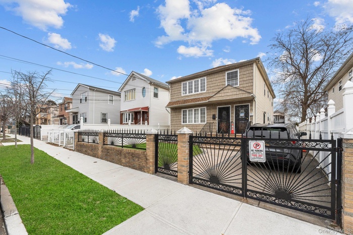 View of front of home with a fenced front yard, a gate, and a residential view