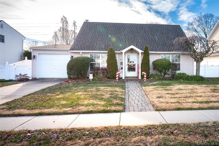 View of front of property with a shingled roof, an attached garage, and driveway