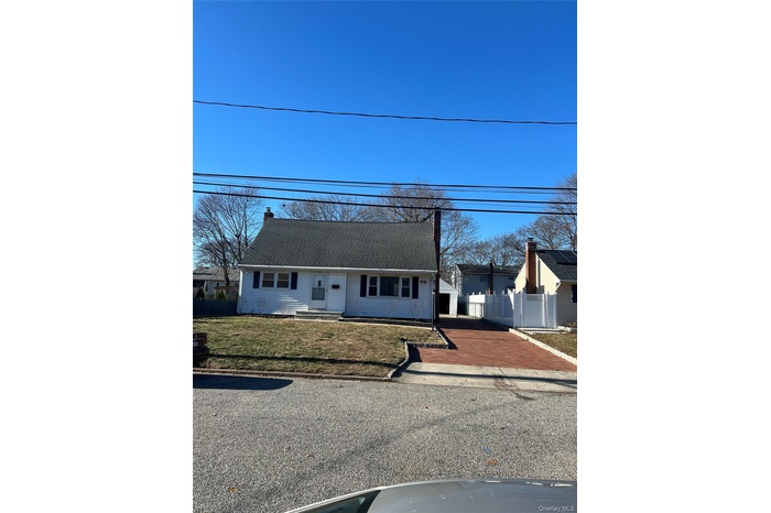 View of front of home featuring a chimney and asphalt driveway