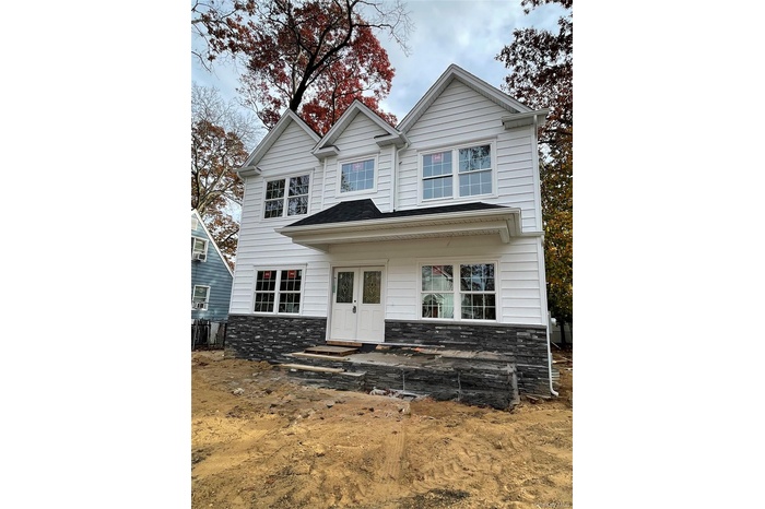 View of front of home with stone siding, french doors, and a porch