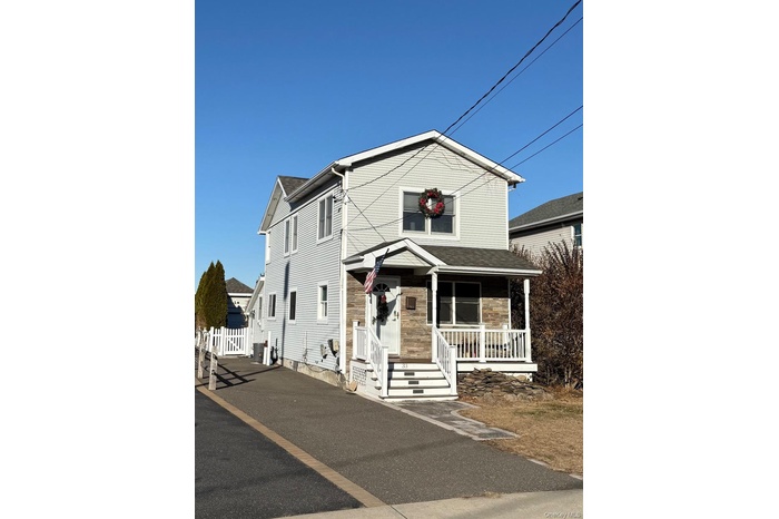 View of front facade with covered porch and stone siding