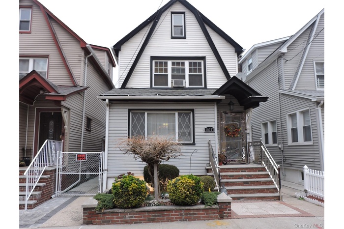 Dutch colonial with a gate and a shingled roof