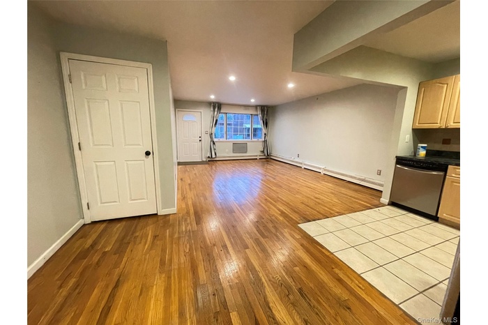 Unfurnished living room with light wood-style floors, recessed lighting, and a baseboard heating unit