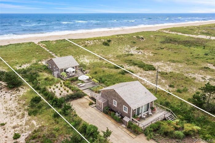 Birds eye view of property with a beach view and a water view