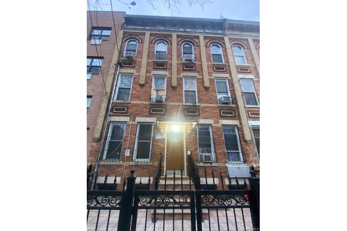 View of front of home featuring brick siding and a fenced front yard