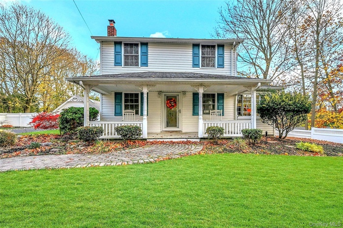 View of front of house featuring a porch and a chimney
