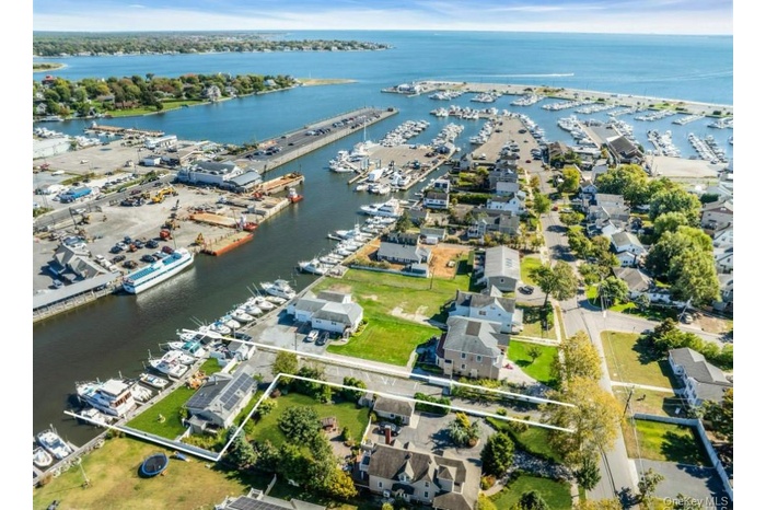 View of property location with property parcel outlined, a marina, and a nearby body of water