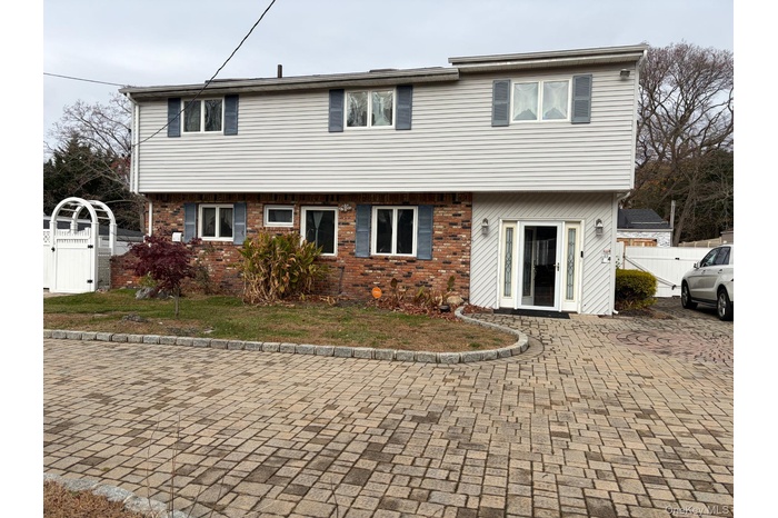 Colonial-style house featuring brick siding and a gate