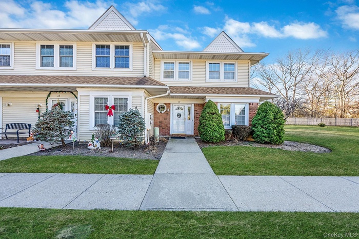 View of front facade with brick siding and roof with shingles