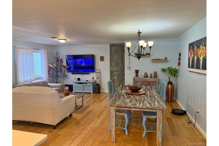 Dining space featuring hardwood / wood-style floors, a barn door, and a chandelier