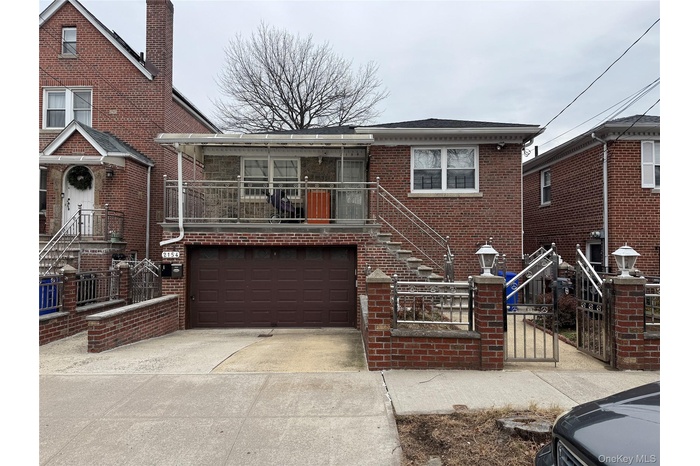 View of front of home featuring brick siding, stairs, a gate, driveway, and a fenced front yard