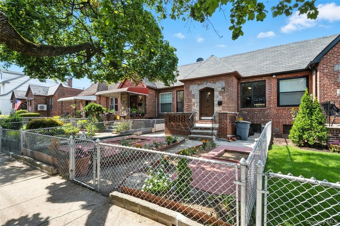 View of front of house featuring a gate, a fenced front yard, a patio, and brick siding
