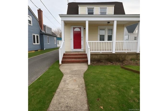 View of front facade featuring covered porch and a front yard