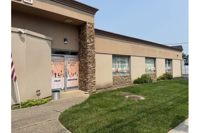 Property entrance featuring a lawn, stucco siding, and stone siding