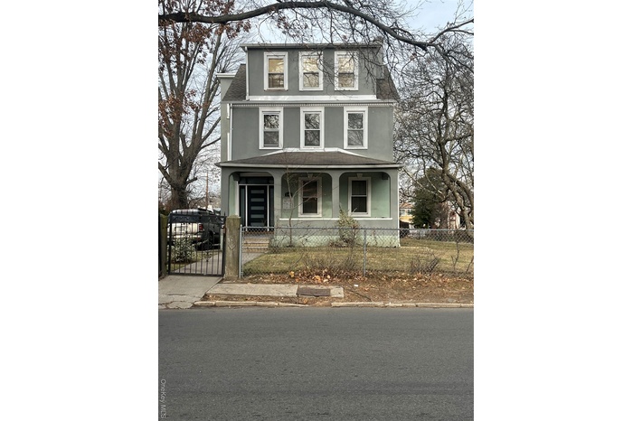 View of front of home with a gate, stucco siding, covered porch, and a fenced front yard