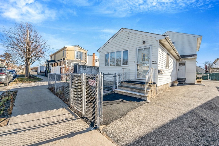 View of front of home with a gate, a fenced front yard, and entry steps